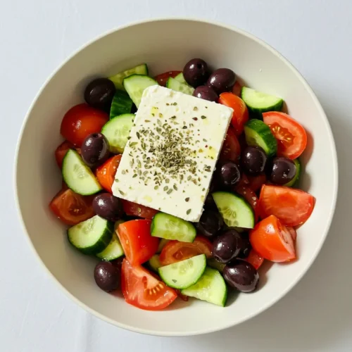 Greek salad with cucumbers, tomatoes, olives, and feta cheese.
