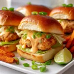 Bang Bang Chicken Sliders on a wooden tray with sauce and fries